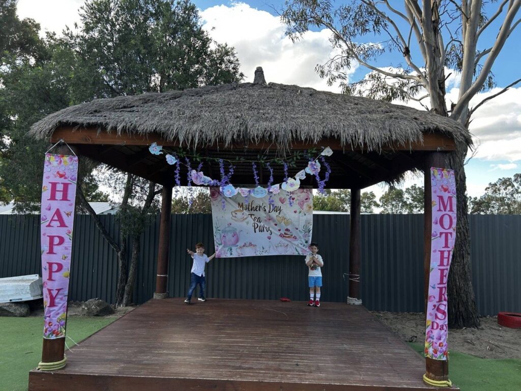 Outdoor stage decorated with Happy Mother's Day banners at Treasure Cove