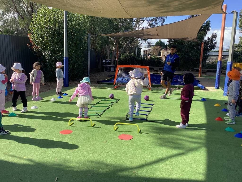 Children moving through agility ladders and cones during soccer training