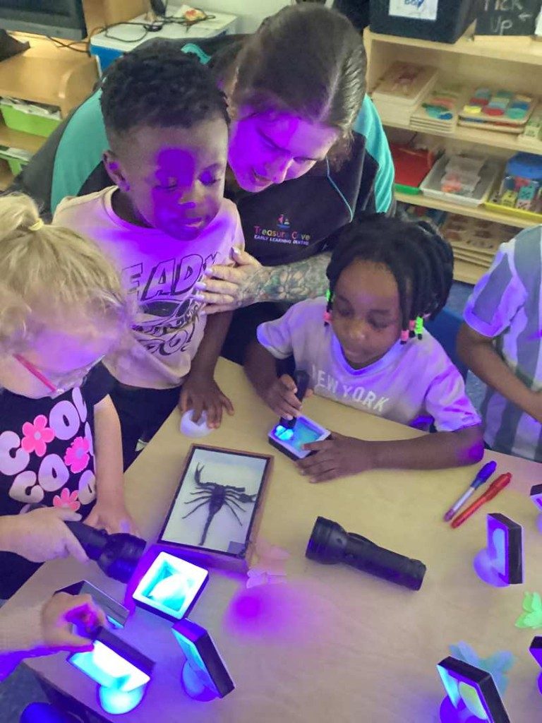 Children exploring UV light and glowing materials at the table
