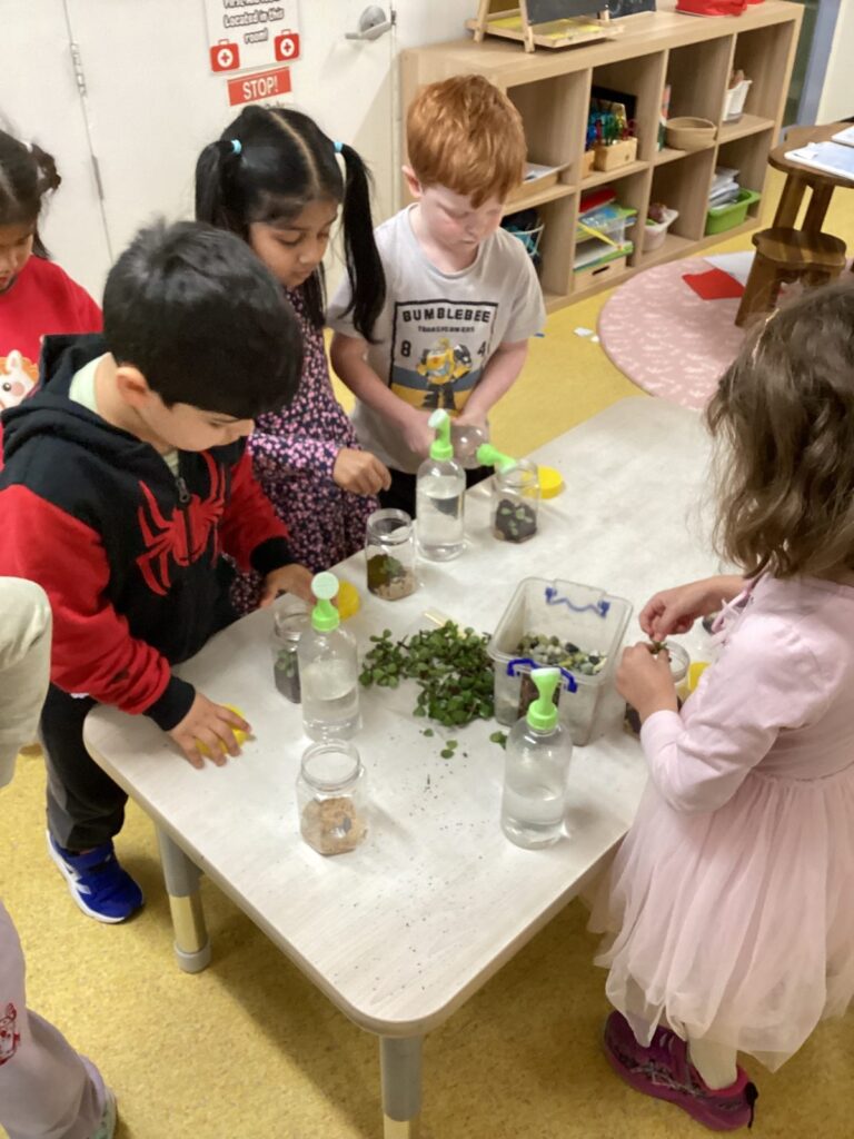 Children filling jars with soil and seeds during a planting activity